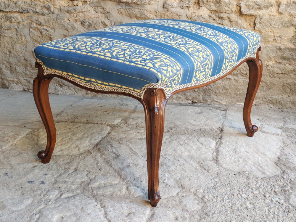 An antique walnut stool featuring carved cabriole legs and a patterned blue and yellow striped upholstered top with gimp trim. View IV