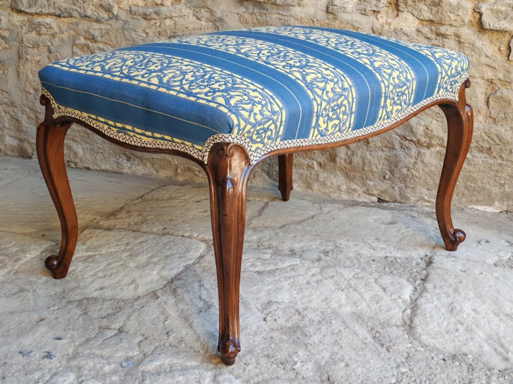 An antique walnut stool featuring carved cabriole legs and a patterned blue and yellow striped upholstered top with gimp trim. View VIII