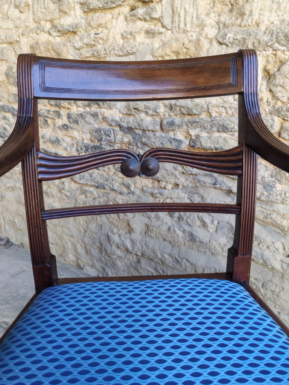 A late Georgian mahogany carver chair featuring carved reeded back rails, curved armrests, and a blue patterned drop-in seat. View II