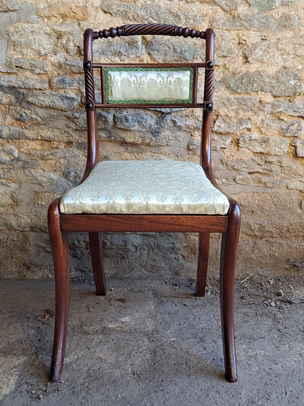 A set of ten 19th-century rosewood dining chairs featuring carved rope-twist top rails, curved sabre legs, and pale green upholstered seats. View II
