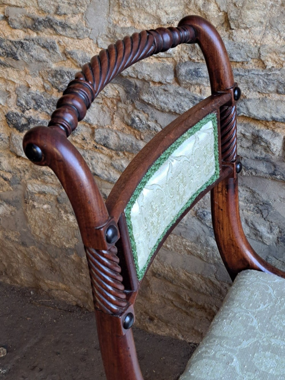 A set of ten 19th-century rosewood dining chairs featuring carved rope-twist top rails, curved sabre legs, and pale green upholstered seats. View VI