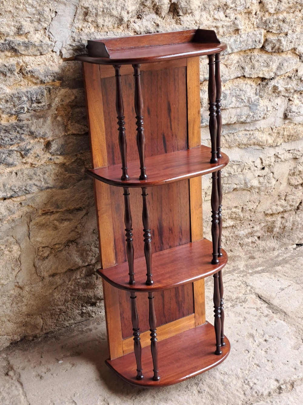 A four-tiered mahogany hanging wall shelf with turned spindle supports and a solid timber backboard. View II