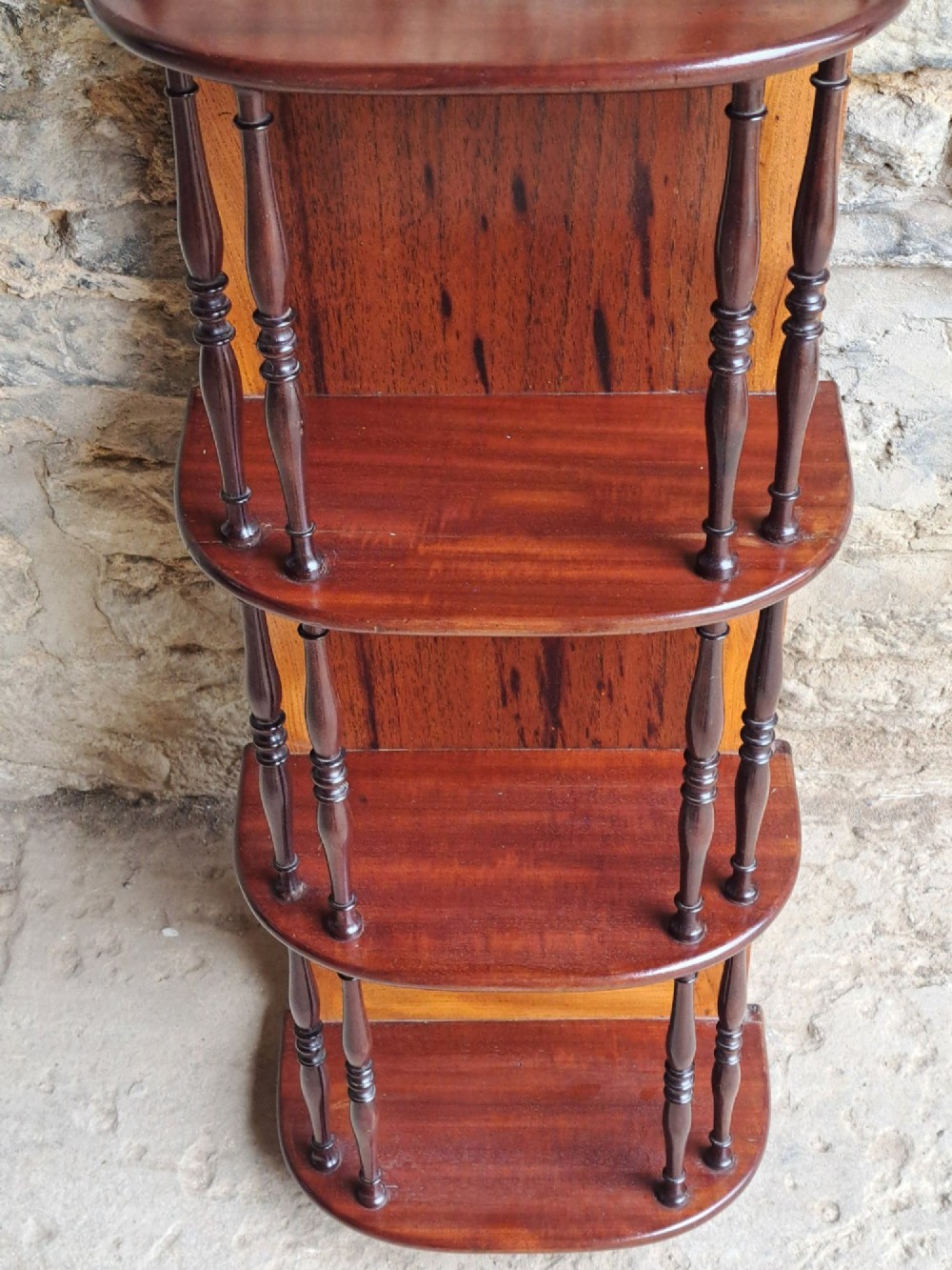 A four-tiered mahogany hanging wall shelf with turned spindle supports and a solid timber backboard. View III