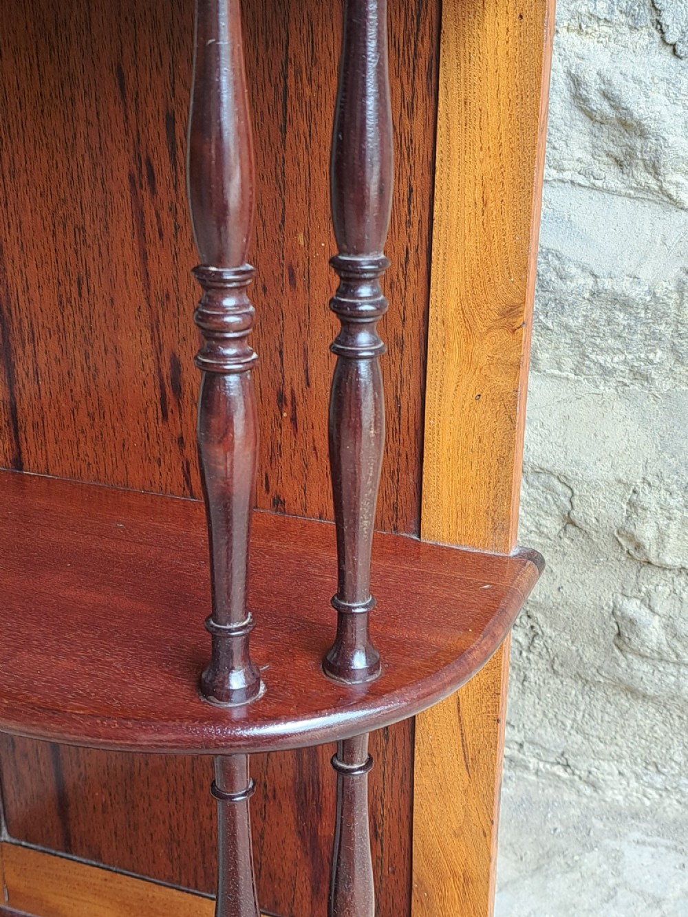 A four-tiered mahogany hanging wall shelf with turned spindle supports and a solid timber backboard. View V