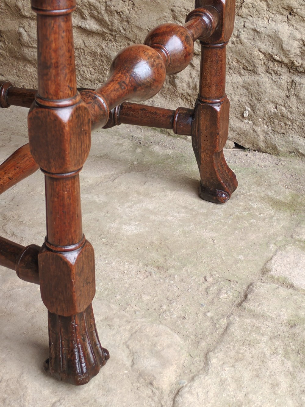 An early 18th-century dark walnut side chair featuring a high back with woven cane panels and central wooden splat, a caned seat, and turned legs with carved feet. View VIII