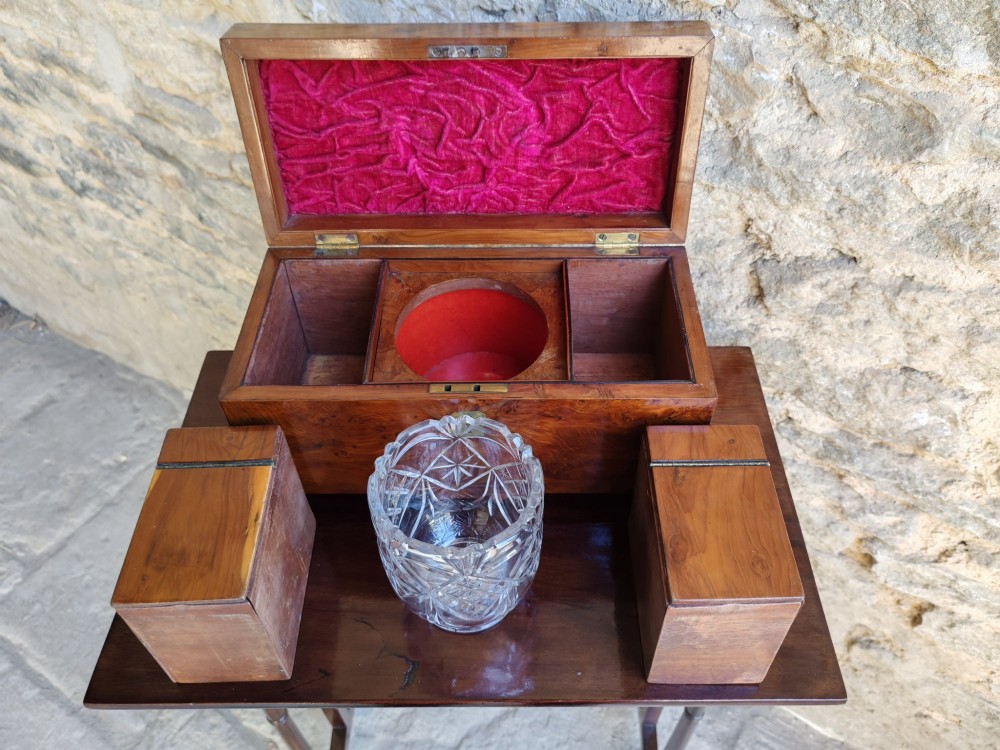 An 18th-century Georgian yew wood tea caddy featuring rich grain figure, a top brass handle, a brass escutcheon, and bun feet. View VI