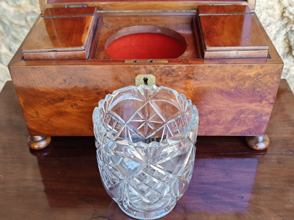 An 18th-century Georgian yew wood tea caddy featuring rich grain figure, a top brass handle, a brass escutcheon, and bun feet. View VII