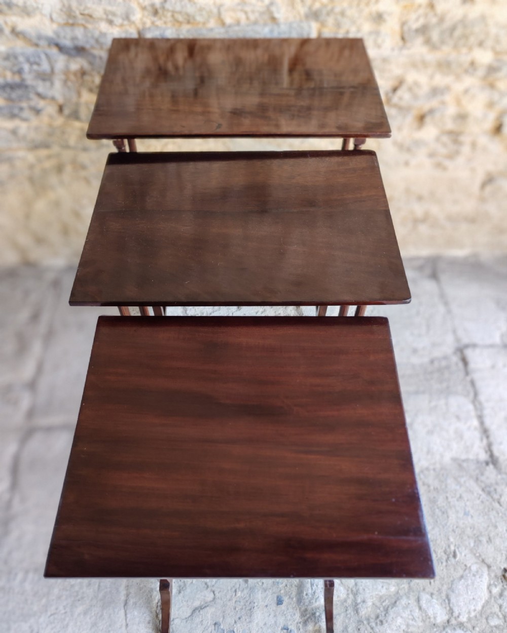 A set of three graduated Georgian mahogany nesting tables with slender turned legs and curved stretchers. View II