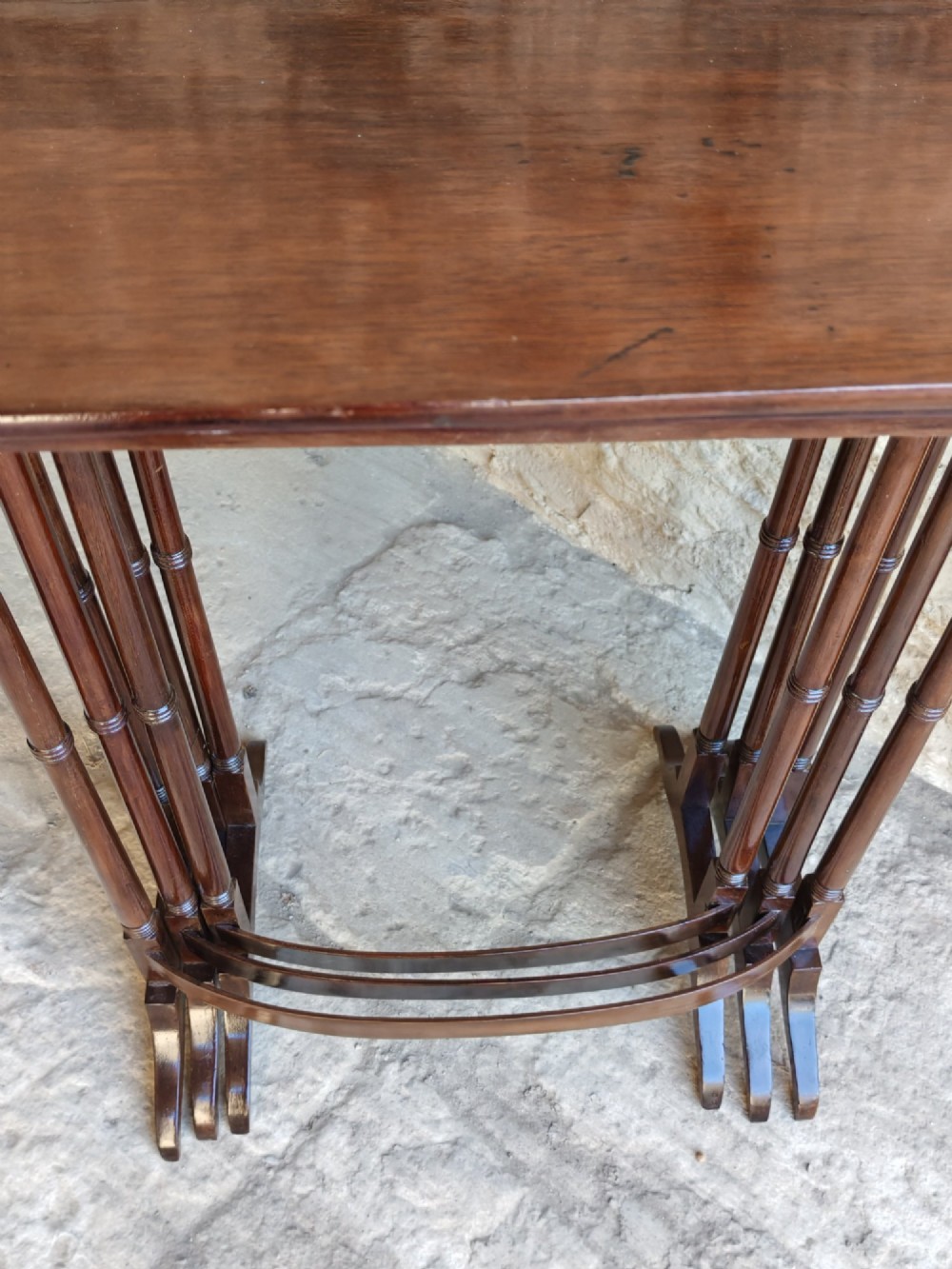 A set of three graduated Georgian mahogany nesting tables with slender turned legs and curved stretchers. View V