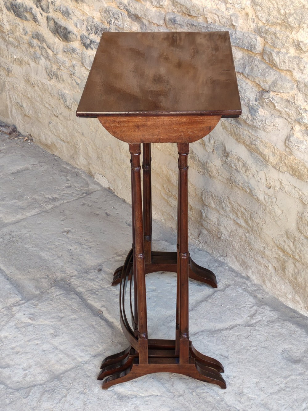 A set of three graduated Georgian mahogany nesting tables with slender turned legs and curved stretchers. View VIII