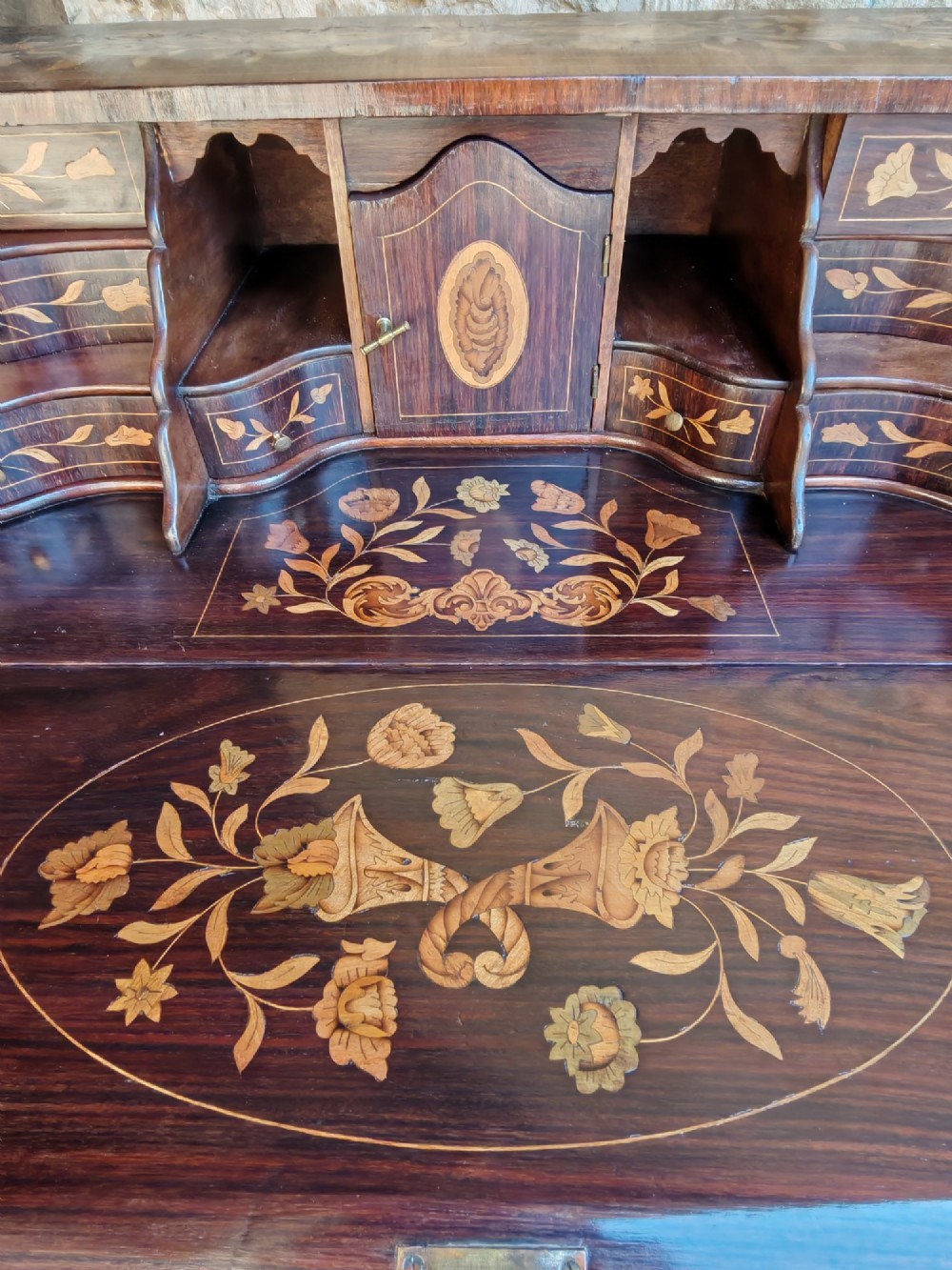 An antique Dutch walnut cylinder bureau decorated with floral marquetry inlays, resting on slender cabriole legs. View XI