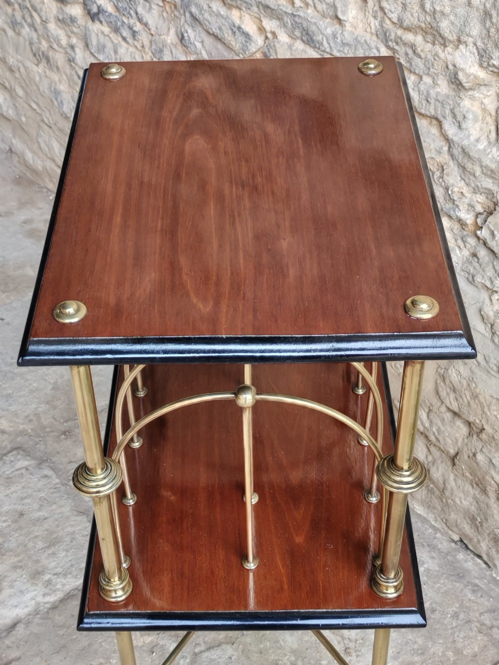 A Regency style two-tier table featuring a polished mahogany top, brass frame with vertical dividers for periodicals, and curved brass legs. View V