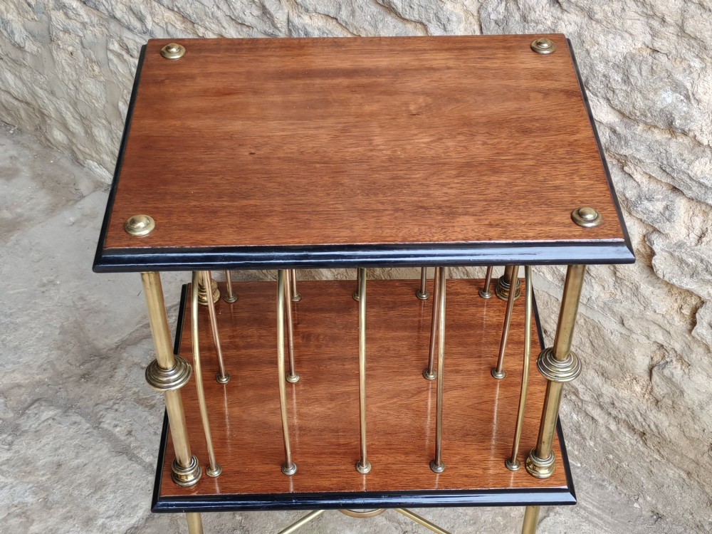 A Regency style two-tier table featuring a polished mahogany top, brass frame with vertical dividers for periodicals, and curved brass legs. View VII