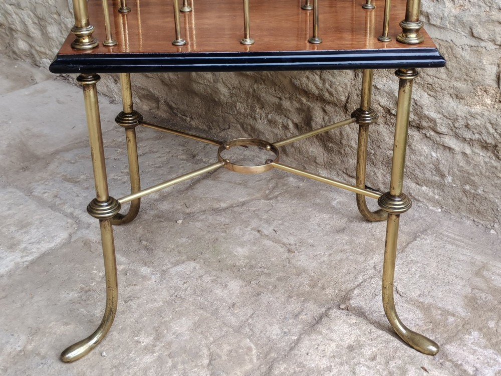 A Regency style two-tier table featuring a polished mahogany top, brass frame with vertical dividers for periodicals, and curved brass legs. View VIII