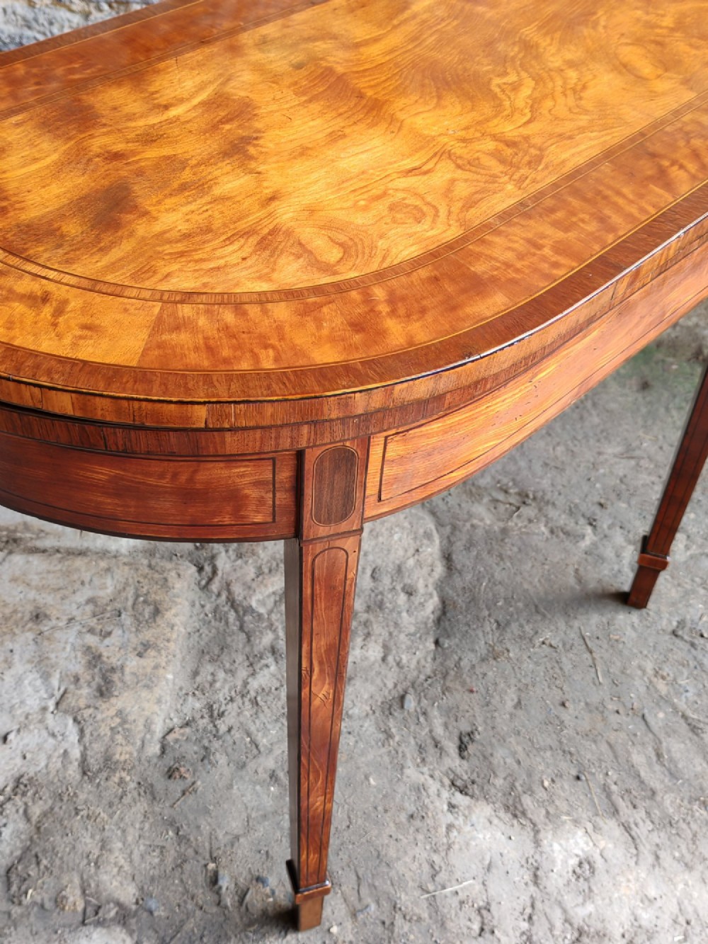 A late 18th-century D-shaped satinwood card table with fine crossbanding, stringing inlay, and square tapered legs. View IV