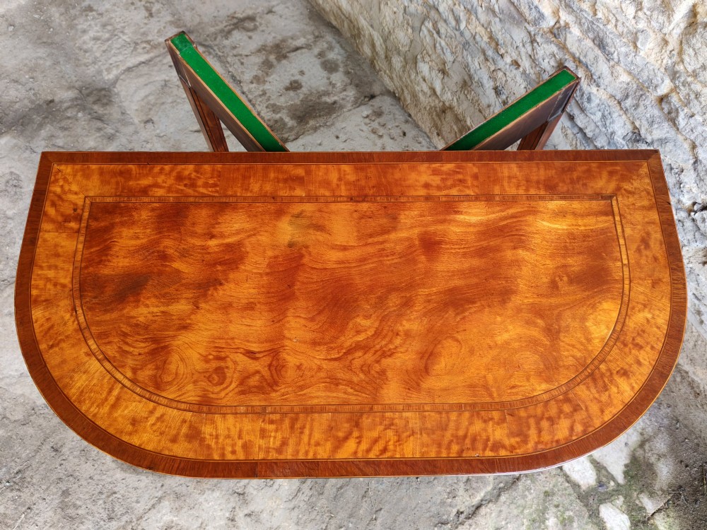 A late 18th-century D-shaped satinwood card table with fine crossbanding, stringing inlay, and square tapered legs. View IX