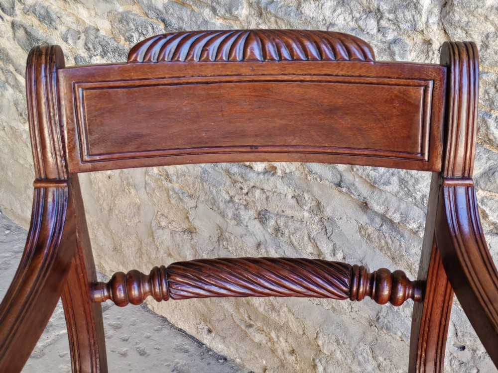 A Regency mahogany carver armchair featuring a carved rope twist rail back, shaped armrests, turned front legs, and a patterned woven seat. View IV