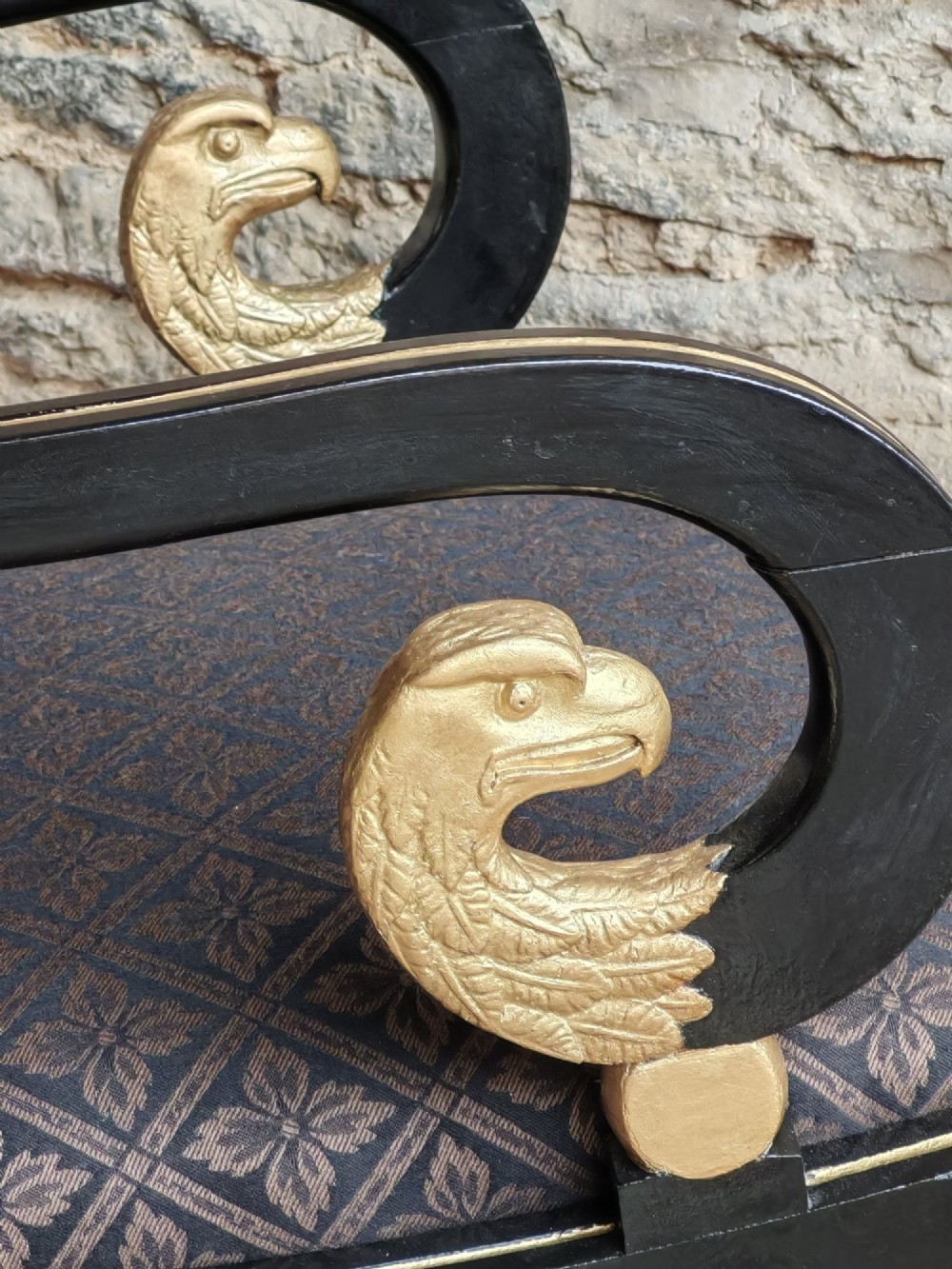 An ebonised and parcel-gilt Regency armchair featuring carved eagle head arm terminals, reeded scroll bars, patterned purple fabric upholstery, and gold paw feet. View VII