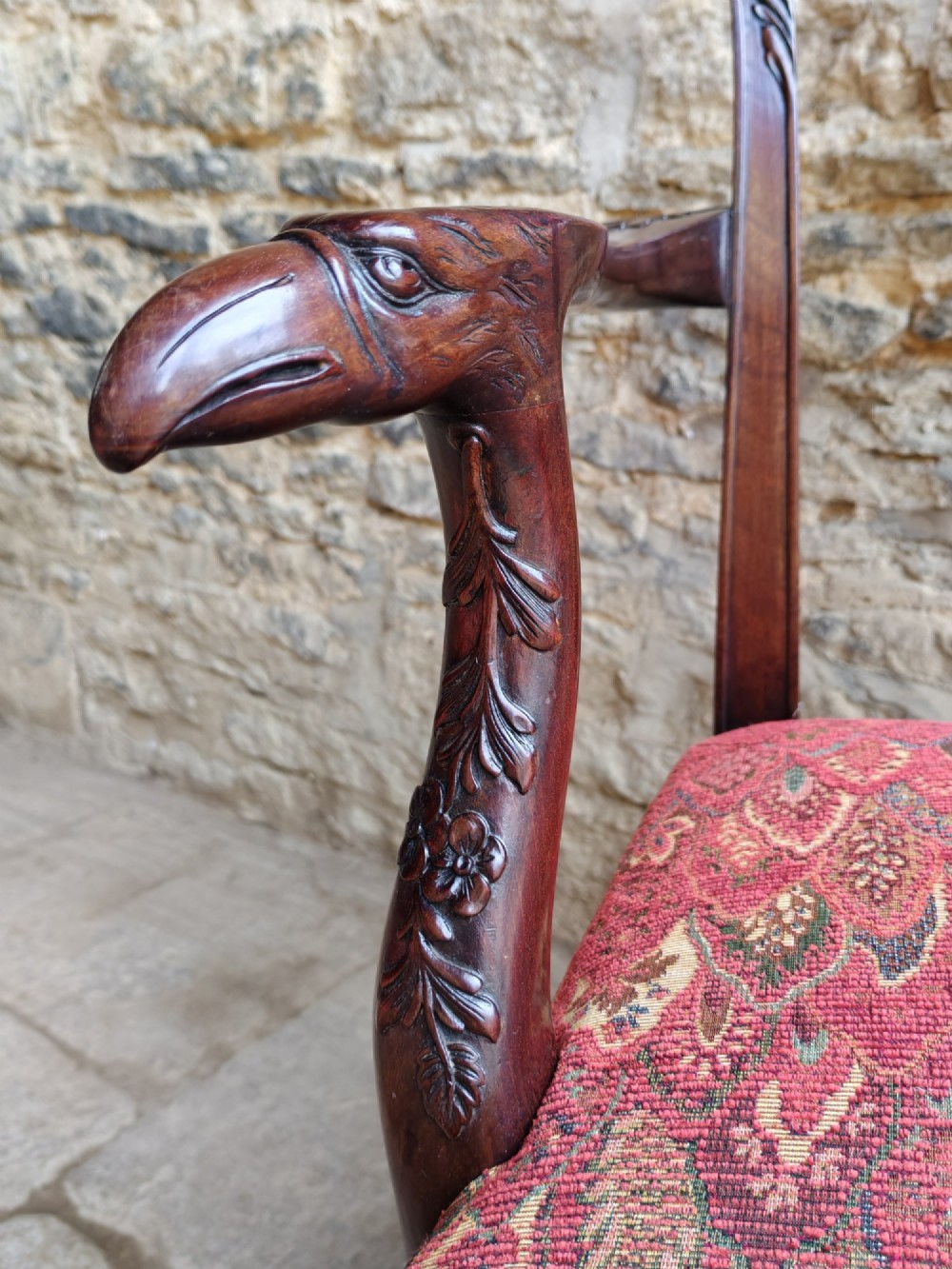 A dark mahogany Chippendale revival carver armchair with an intricately carved splat back and red patterned fabric seat cushion. View VI