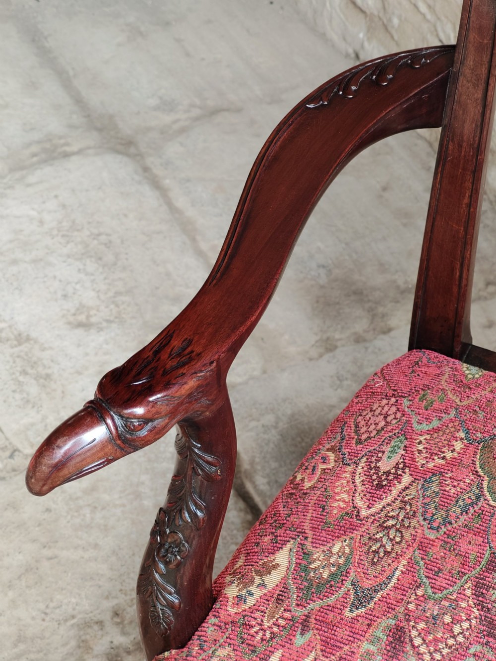 A dark mahogany Chippendale revival carver armchair with an intricately carved splat back and red patterned fabric seat cushion. View VII