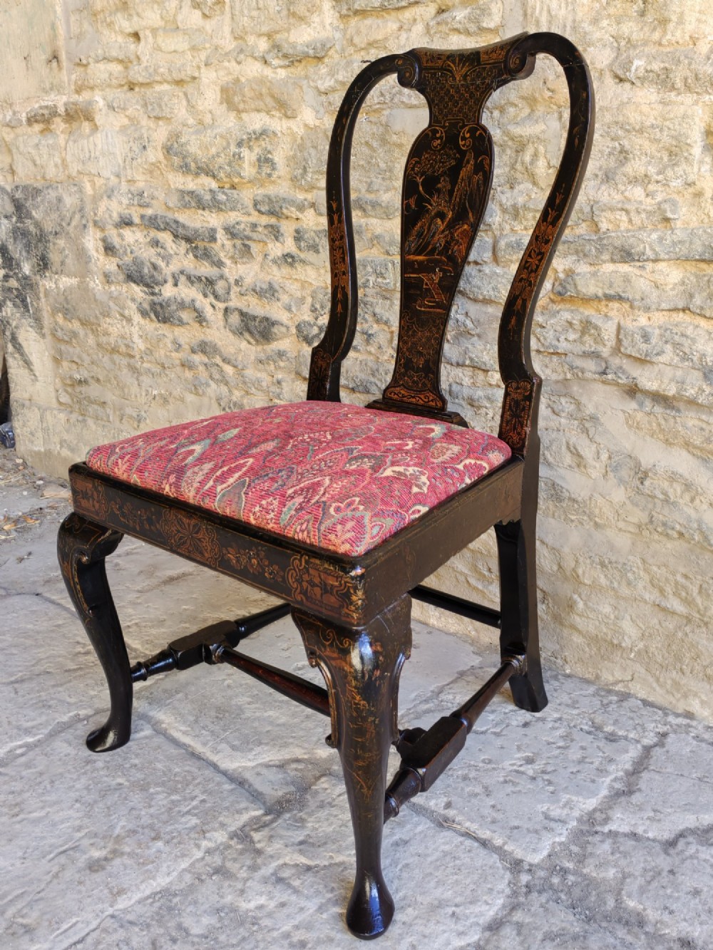 An early 18th-century Queen Anne side chair featuring black japanned lacquer with detailed gold Chinoiserie decorations, a vase splat back, cabriole legs, and a patterned red upholstery seat. View II