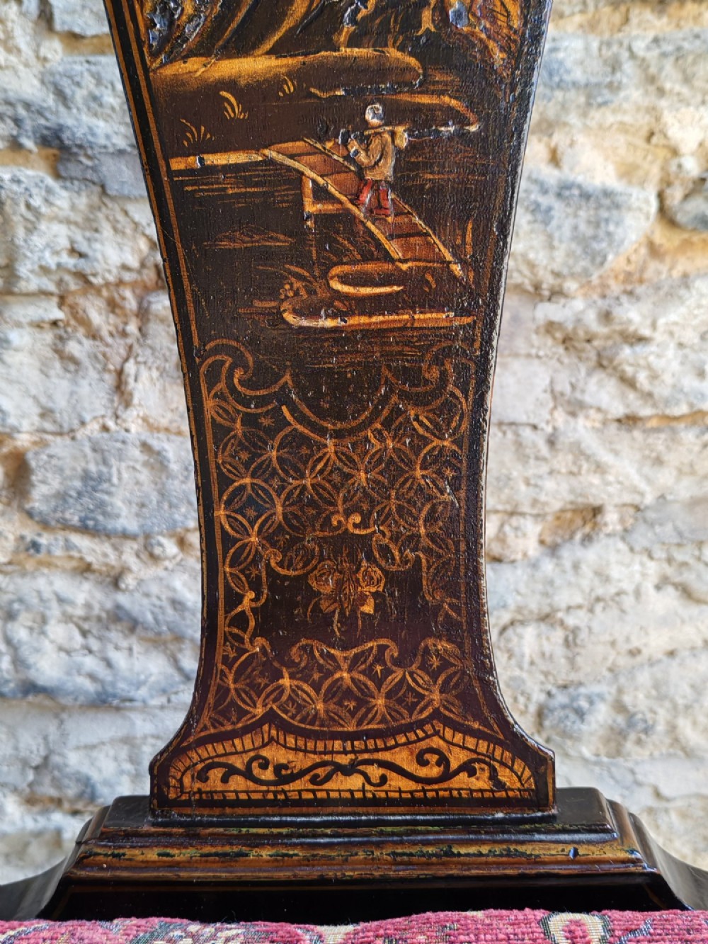 An early 18th-century Queen Anne side chair featuring black japanned lacquer with detailed gold Chinoiserie decorations, a vase splat back, cabriole legs, and a patterned red upholstery seat. View VI