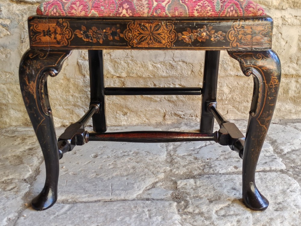 An early 18th-century Queen Anne side chair featuring black japanned lacquer with detailed gold Chinoiserie decorations, a vase splat back, cabriole legs, and a patterned red upholstery seat. View IX