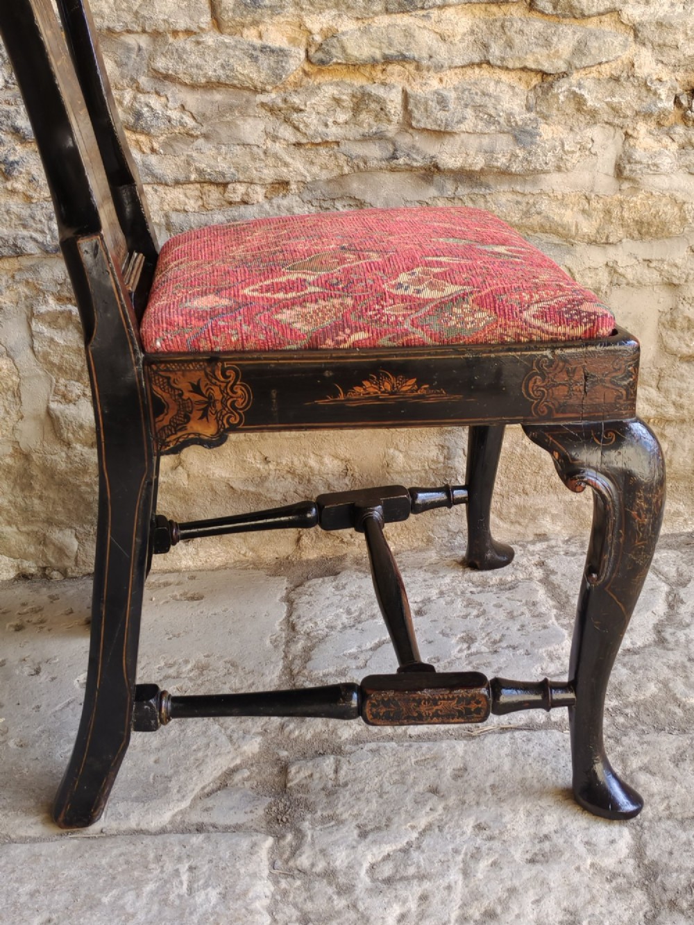 An early 18th-century Queen Anne side chair featuring black japanned lacquer with detailed gold Chinoiserie decorations, a vase splat back, cabriole legs, and a patterned red upholstery seat. View XI