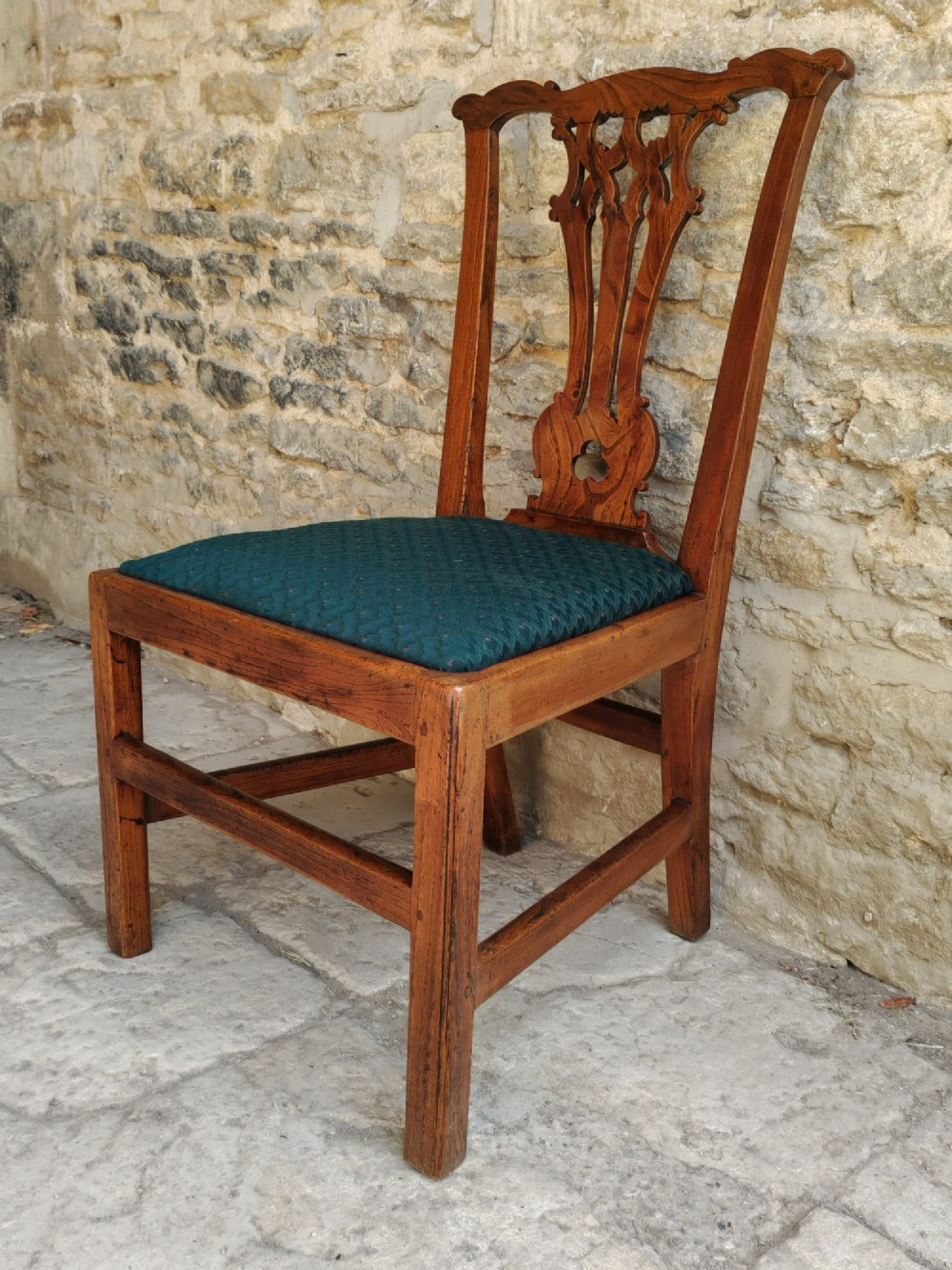 An 18th-century Georgian Chippendale style elm side chair featuring a carved pierced splat back, square legs with an H-stretcher, and a patterned green upholstered seat. View III