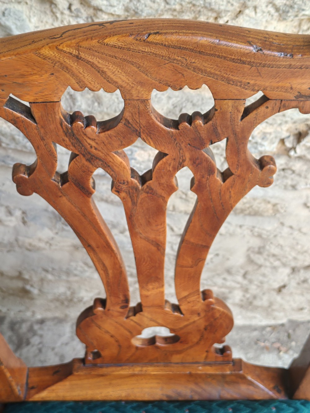 An 18th-century Georgian Chippendale style elm side chair featuring a carved pierced splat back, square legs with an H-stretcher, and a patterned green upholstered seat. View V