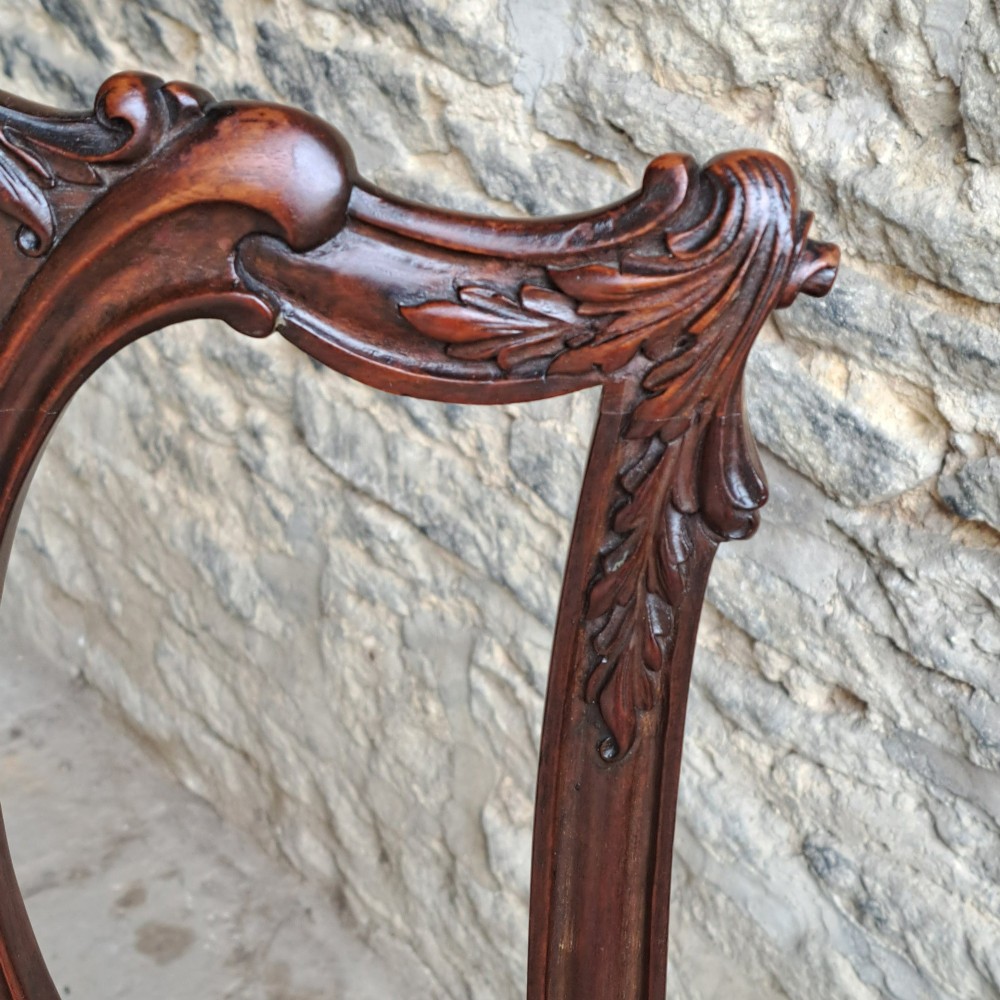A mid 19th-century mahogany Chippendale style side chair featuring a carved pierced back splat, patterned fabric seat, and cabriole legs with ball and claw feet. View V