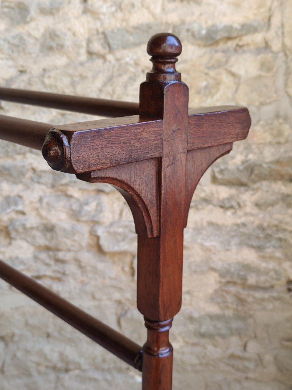 A Victorian dark mahogany freestanding towel rail featuring turned uprights with top finials, multiple horizontal bars, and carved trestle feet. View II