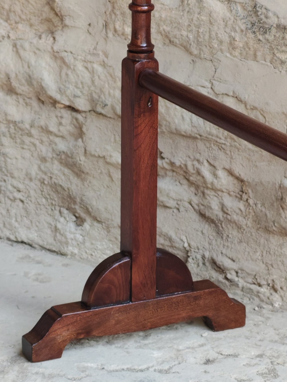A Victorian dark mahogany freestanding towel rail featuring turned uprights with top finials, multiple horizontal bars, and carved trestle feet. View III