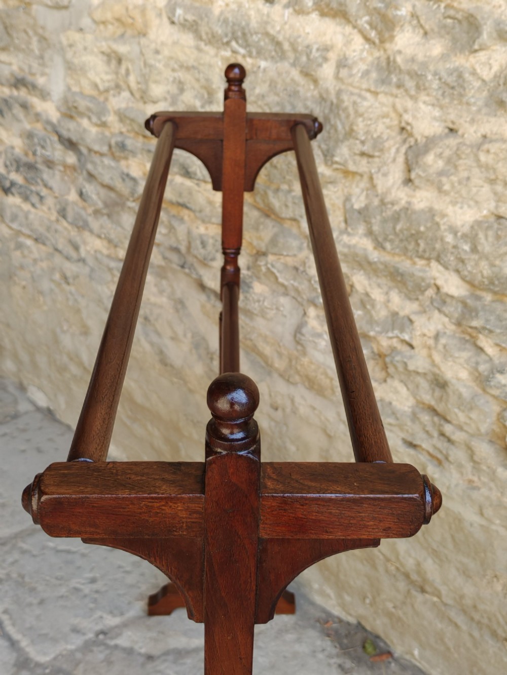 A Victorian dark mahogany freestanding towel rail featuring turned uprights with top finials, multiple horizontal bars, and carved trestle feet. View V