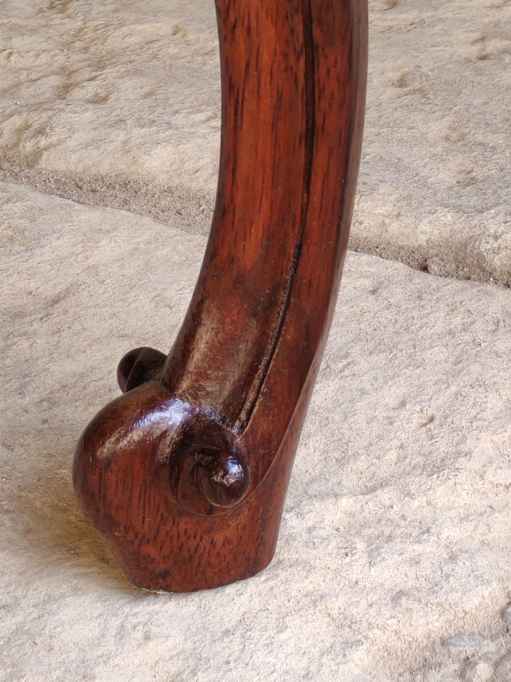 An antique rosewood stool featuring carved cabriole legs and a pink upholstered seat. View IV
