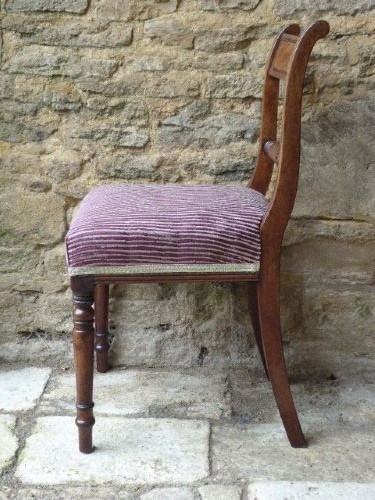 A set of four Regency mahogany dining chairs featuring carved rope-twist cross rails, reeded uprights, turned front legs, and plum striped upholstered seats. View V