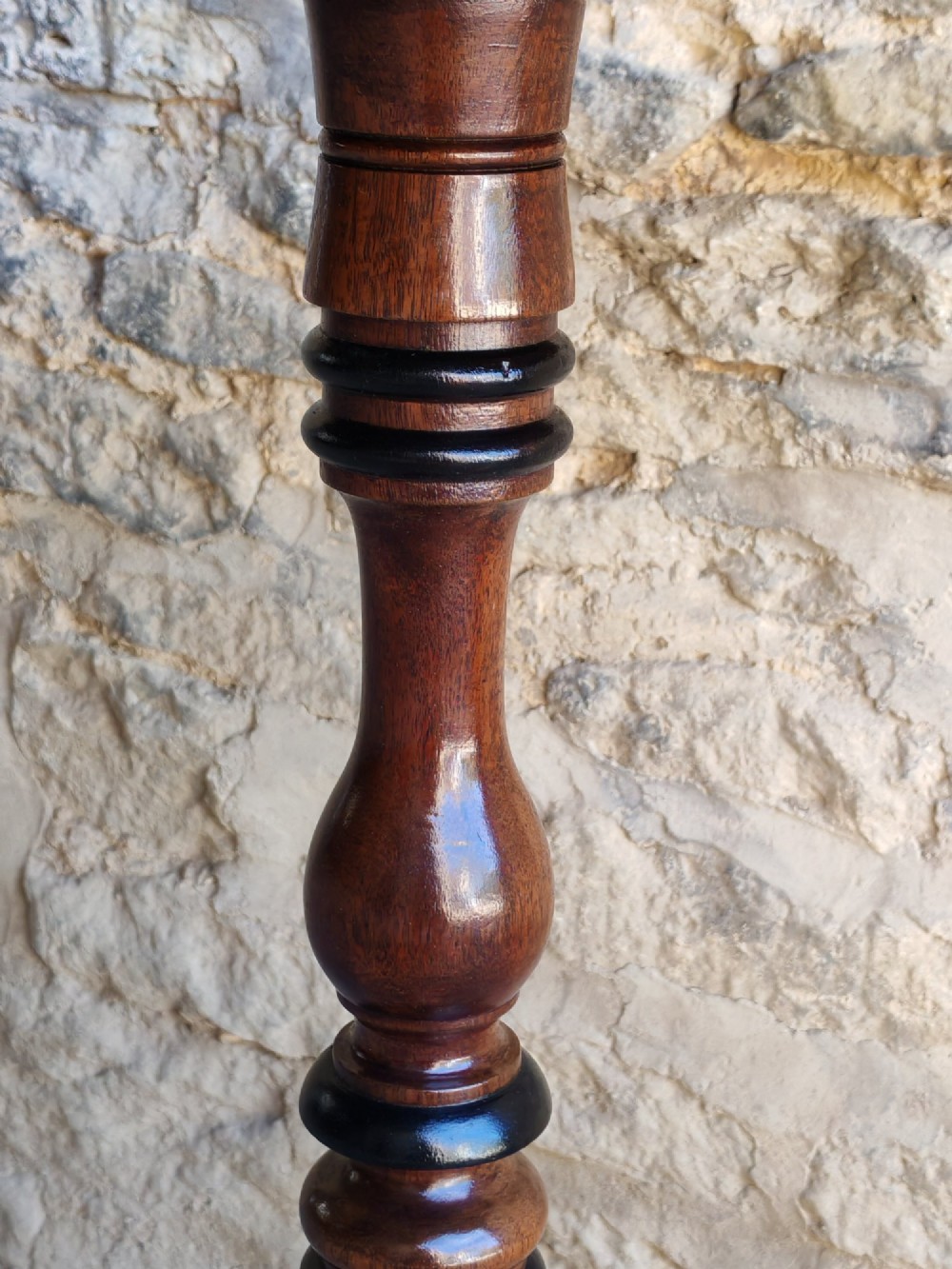 An antique Regency yew wood wine table featuring a rectangular rounded top supported by a turned pedestal stem with ebonised rings on a tripod base. View V