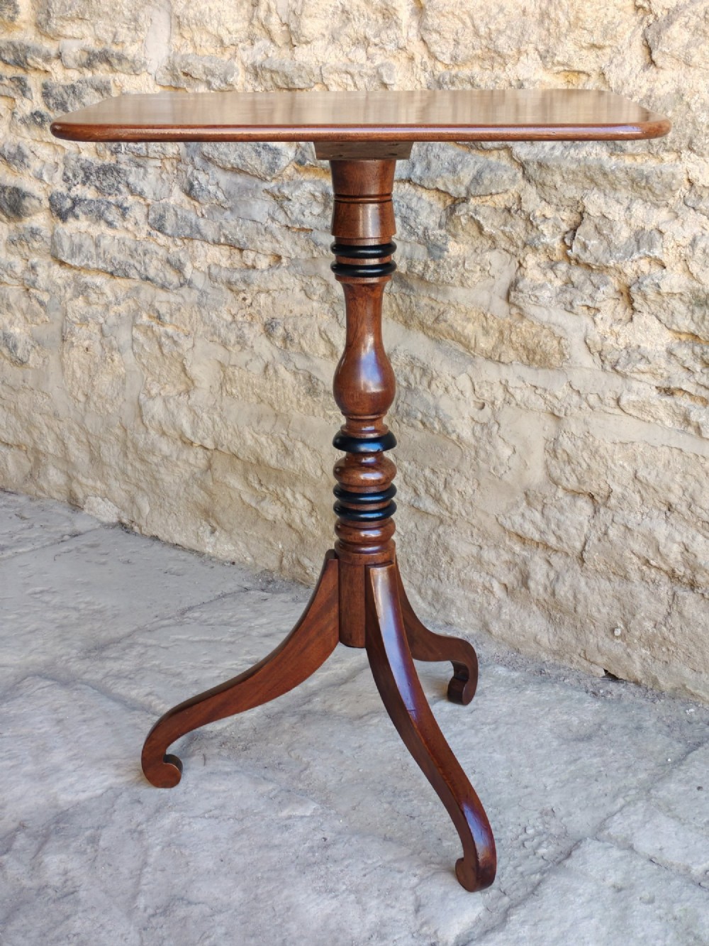 An antique Regency yew wood wine table featuring a rectangular rounded top supported by a turned pedestal stem with ebonised rings on a tripod base. View VIII