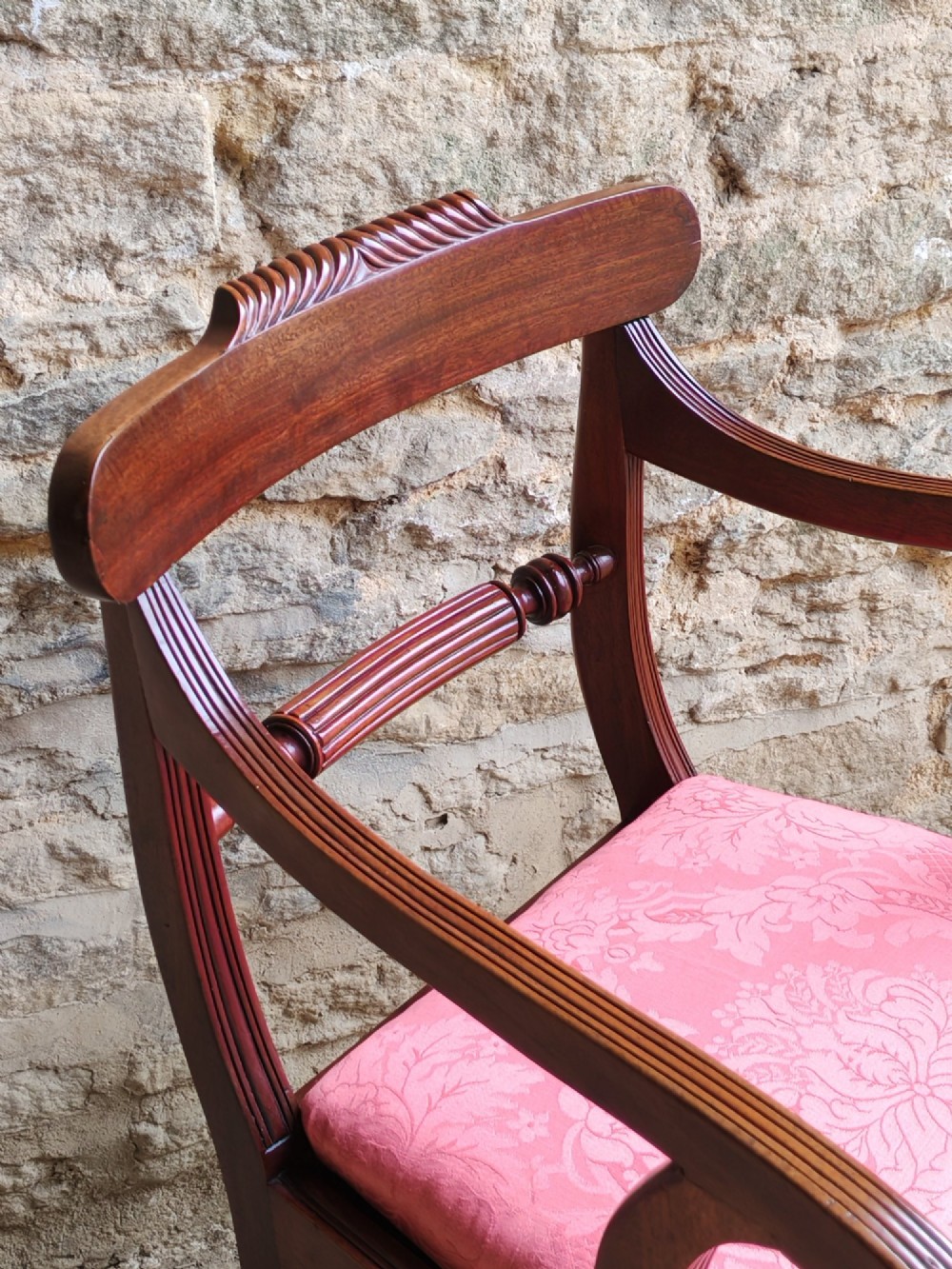 A Regency mahogany carver chair featuring scroll arms, a rope-twist carved rail, reeded legs, and a pink patterned seat cushion. View VIII