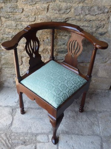 A walnut Queen Anne corner chair with a curved horseshoe armrest, two pierced splats, a green patterned upholstered drop-in seat, and a front cabriole leg. View VI