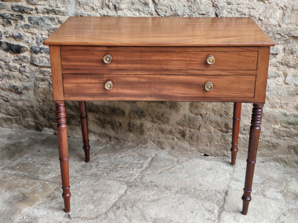 A mid-19th century mahogany work table with an open hinged lid revealing a removable fitted compartment tray set atop turned legs. View II