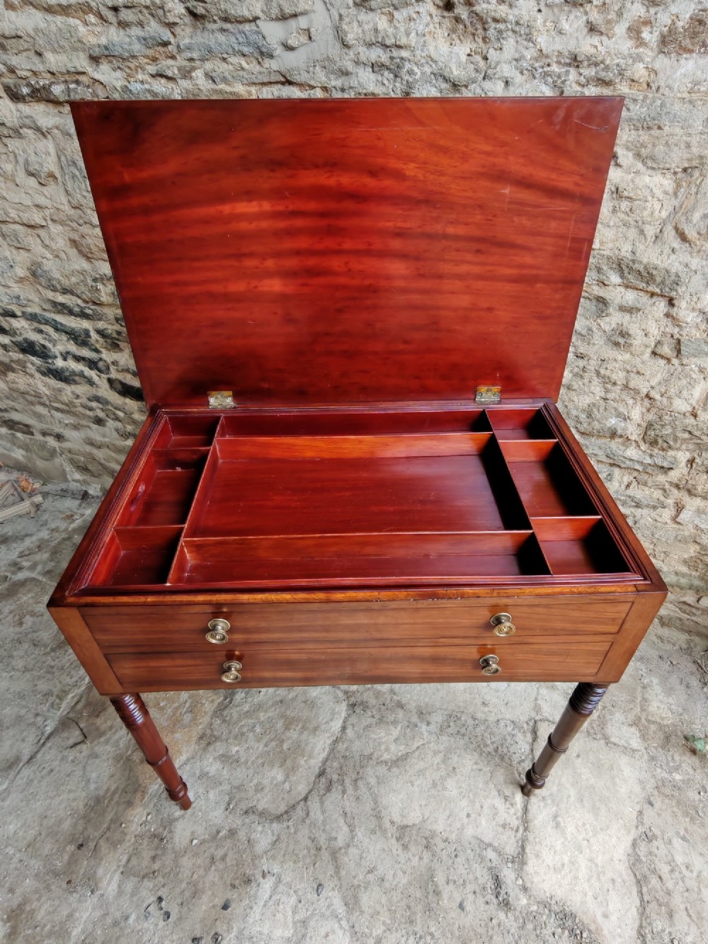 A mid-19th century mahogany work table with an open hinged lid revealing a removable fitted compartment tray set atop turned legs. View V