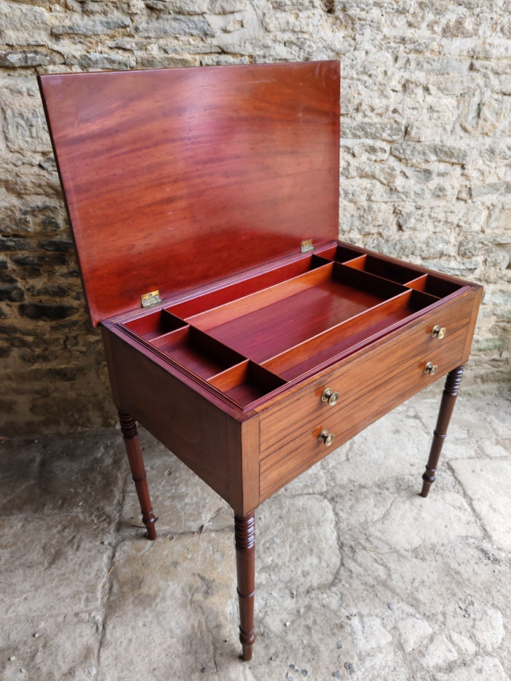 A mid-19th century mahogany work table with an open hinged lid revealing a removable fitted compartment tray set atop turned legs. View VI