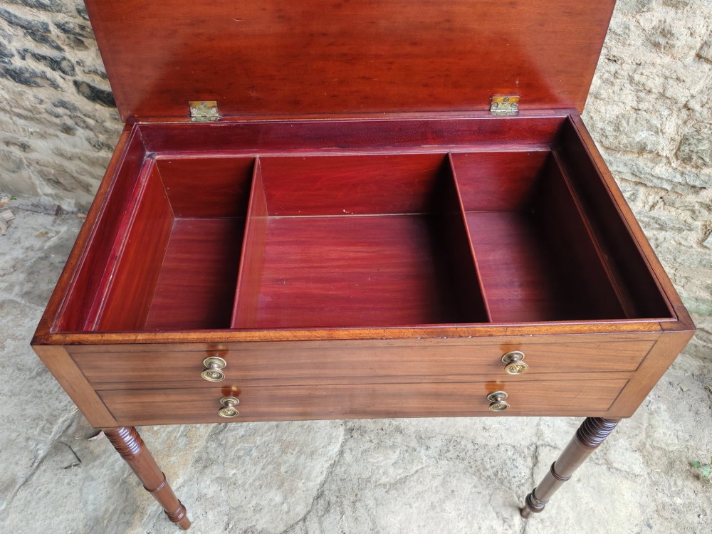 A mid-19th century mahogany work table with an open hinged lid revealing a removable fitted compartment tray set atop turned legs. View VII
