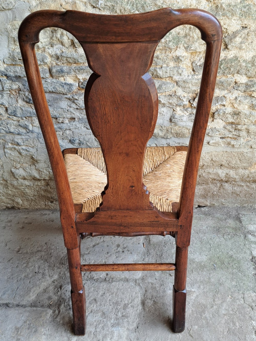 An early 18th-century Queen Anne walnut side chair featuring a vase-shaped splat back, woven rush seat, cabriole front legs, and turned stretchers. View VIII