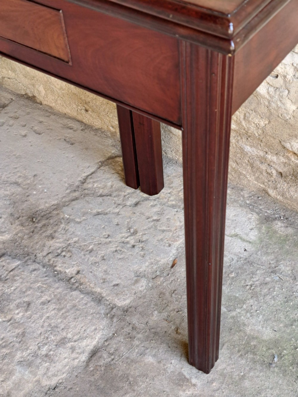 A George III Cuban mahogany fold-over tea table featuring a single frieze drawer with a brass swan-neck handle and straight moulded legs. View VIII