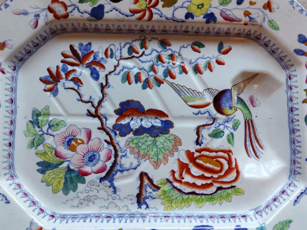 An octagonal Masons ironstone meat platter decorated with a multi-coloured hand-painted chinoiserie motif featuring a bird, flowering branches, and integrated drainage grooves. View II