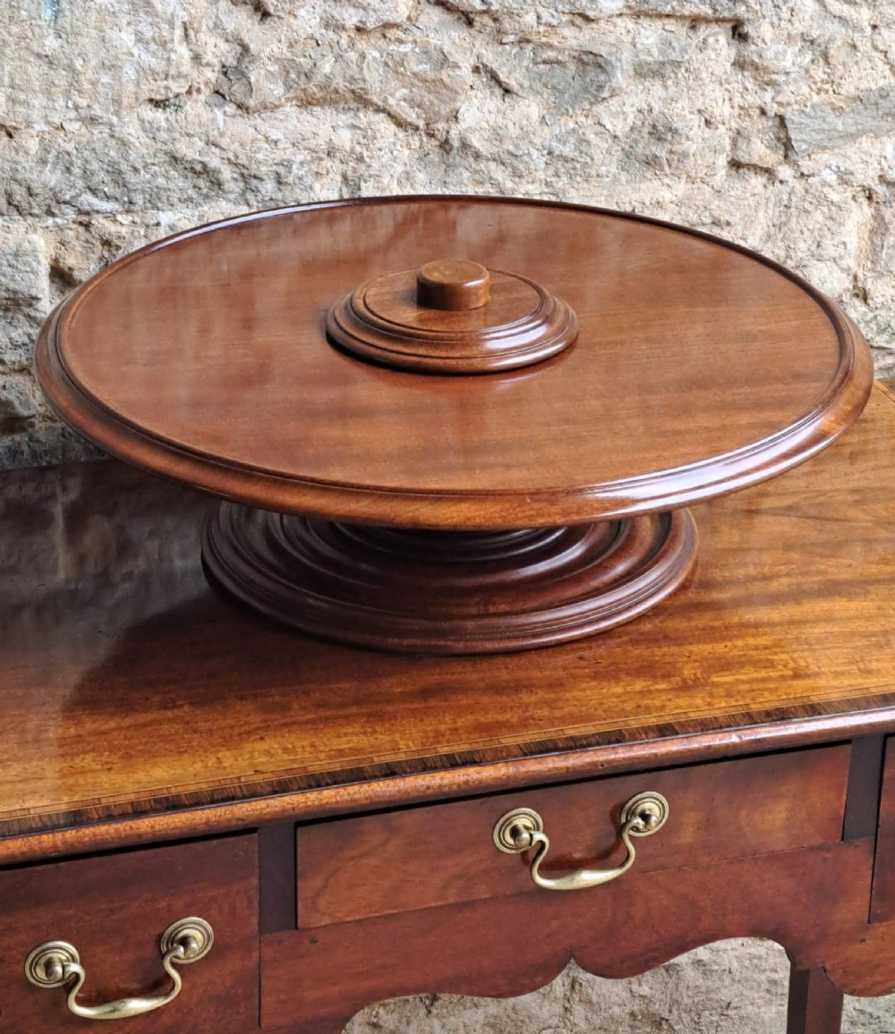 A circular Victorian mahogany Lazy Susan featuring a raised central handle and a turned moulded base. View III
