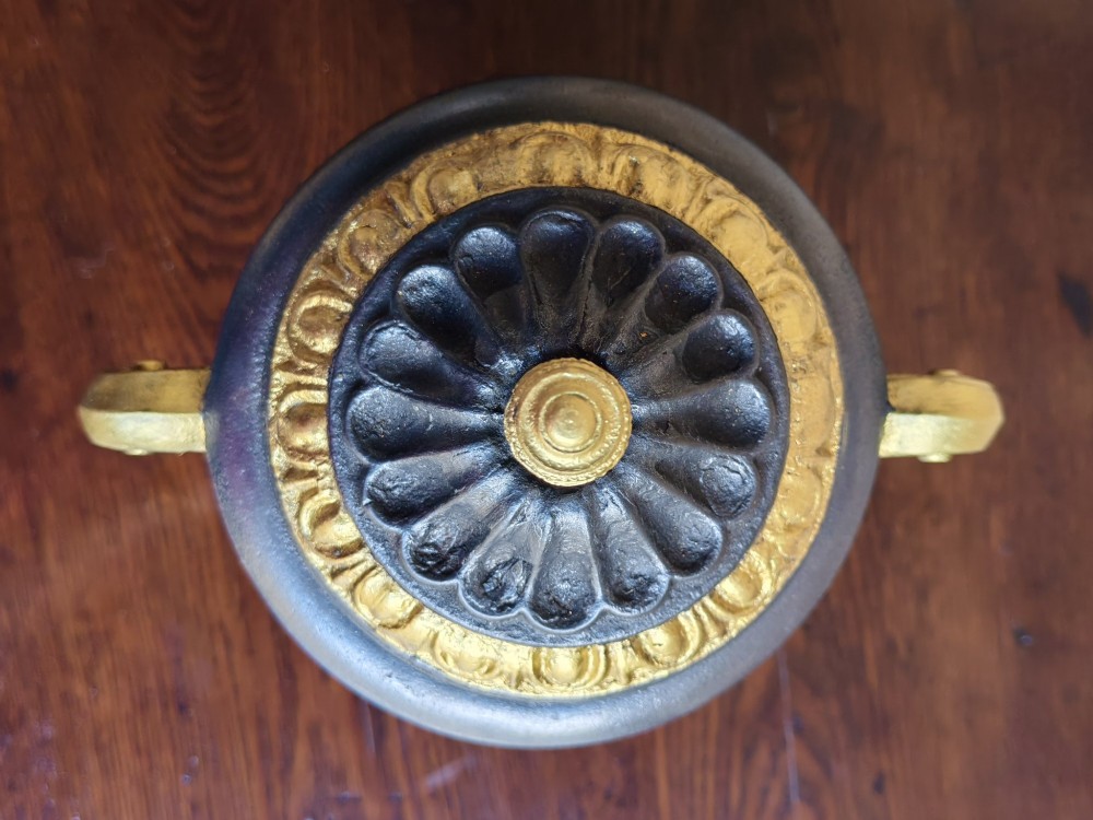 A Victorian cast iron covered urn with parcel-gilded acanthus handles, a gadrooned lid, and a square base. View III