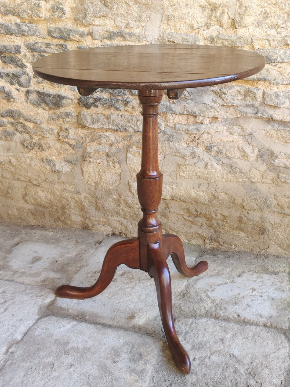 An 18th-century Georgian oak tripod table featuring a circular tilt-top surface positioned vertically on a turned baluster column and three curved legs. View III
